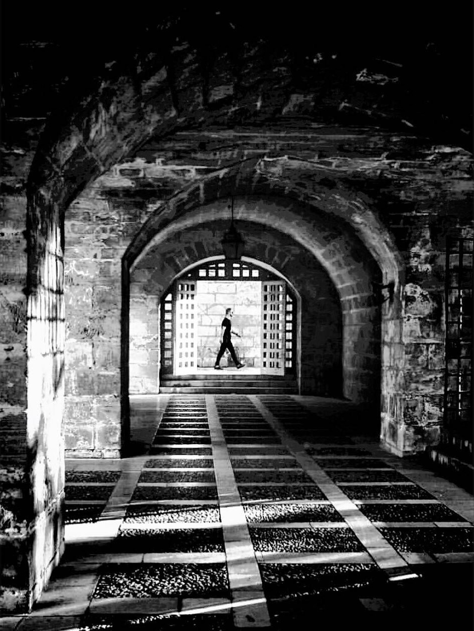 Figure crossing a vaulted passage in Palma